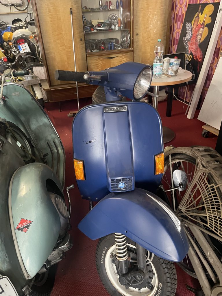 Dunkelblaue Vespa von vorne